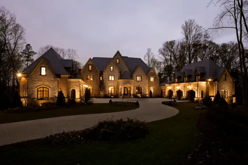 Estate home at night with landscape lighting
