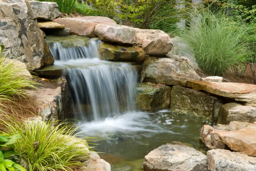 Stacked stone waterfall feature with plantings