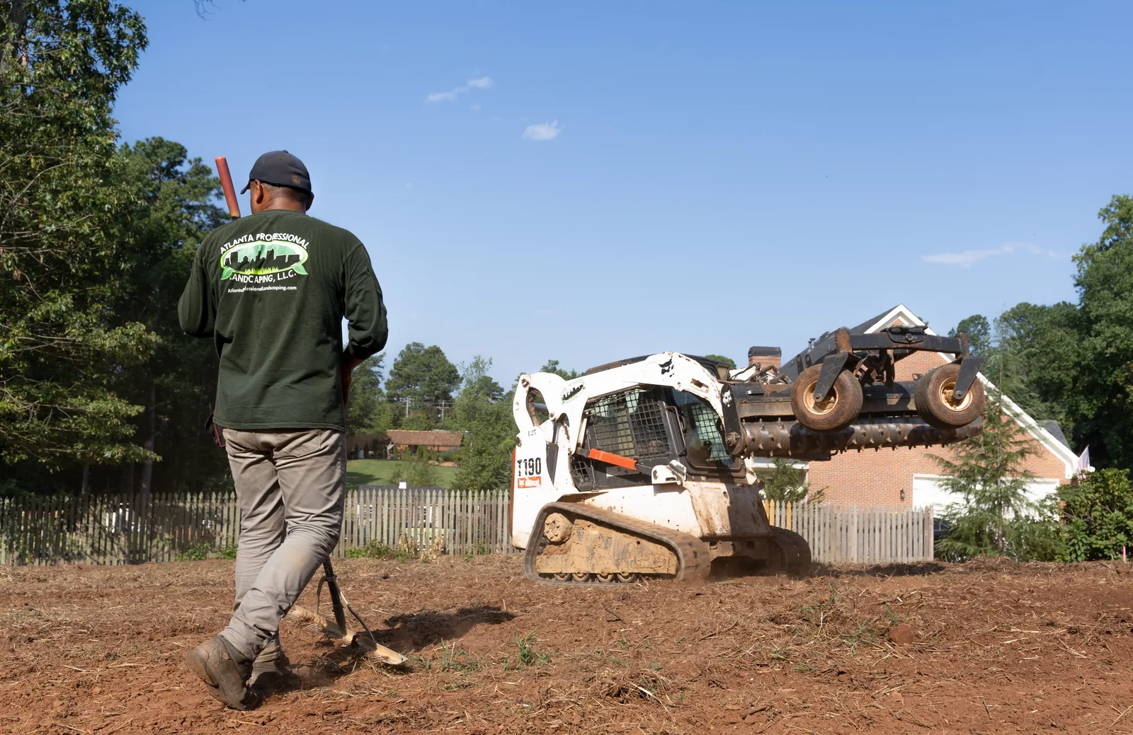 Crew raking graded soil