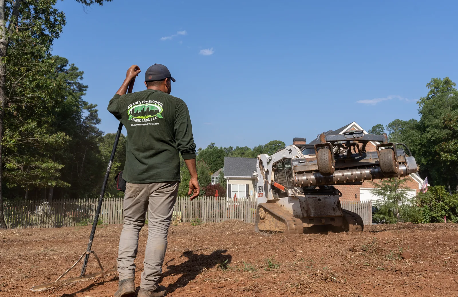 Crew raking graded soil